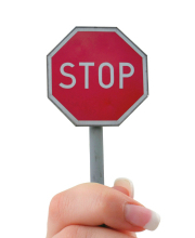 Fingers holding stop sign